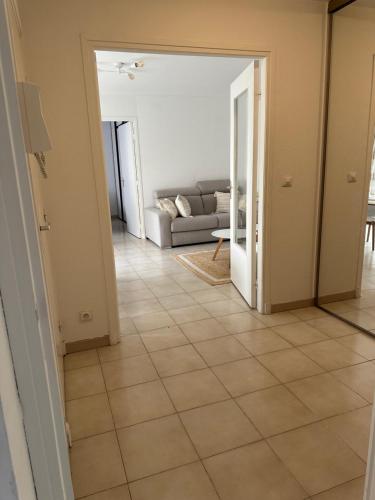 a living room with a couch and a tile floor at Appartement sans mauvaise surprises (2) in Juan-les-Pins