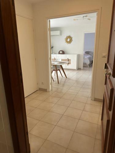 a kitchen and dining room with a table and a tiled floor at Appartement sans mauvaise surprises (2) in Juan-les-Pins