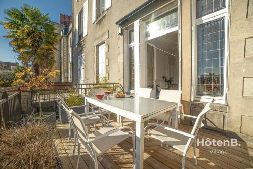 a white table and chairs on a balcony at The "Heritage" Heart of Limoges Parking AC and Private Terrace in Limoges