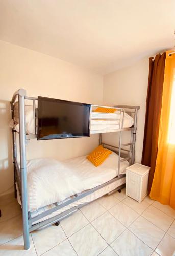 Cette chambre dispose de lits superposés avec des draps blancs. dans l'établissement APPARTEMENT GRAU DU ROI - FRONT DE MER - CENTRE VILLE -RIVE GAUCHE, au Grau-du-Roi