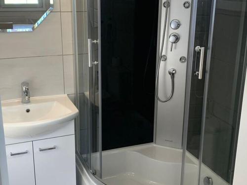 a shower with a glass door next to a sink at Comfortable holiday homes in Dziwnówek in Dziwnówek