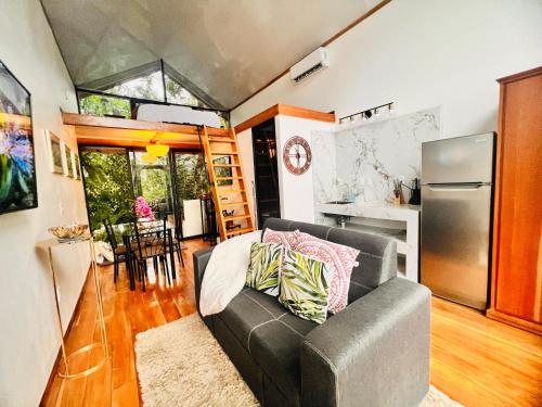 a living room with a couch and a kitchen at Guest House Pura Vida in Quepos