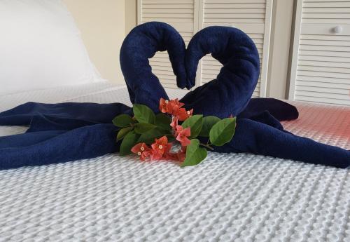two blue towels and flowers on a bed at Memwa Villas in Castries