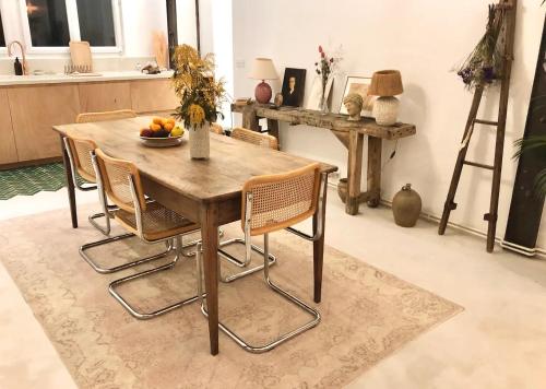 - une table à manger avec des chaises et une corbeille de fruits dans l'établissement Luxurious loft in the heart of Belleville (2 bedrooms), à Paris