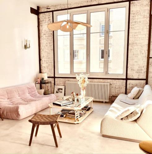 un salon avec un canapé rose et une table dans l'établissement Luxurious loft in the heart of Belleville (2 bedrooms), à Paris