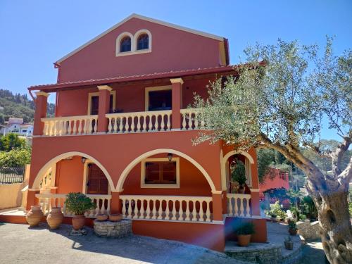a red house with a tree in front of it at Seaside Pool Villa in Mesongi