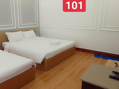 dwa łóżka w pokoju z napisem na ścianie w obiekcie VND Vũng Tàu Hotel & Villa w mieście Vung Tau