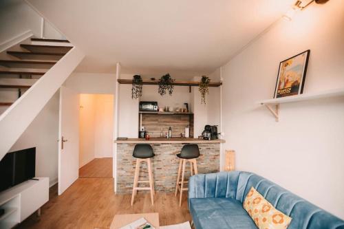 een woonkamer met een blauwe bank en een bar bij Soirée cinéma quartier Mouillère in Besançon