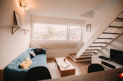 een woonkamer met een blauwe bank en een trap bij Soirée cinéma quartier Mouillère in Besançon