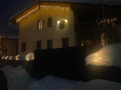 a house with lights on it in the snow at night at Hotel Eden in Mestia