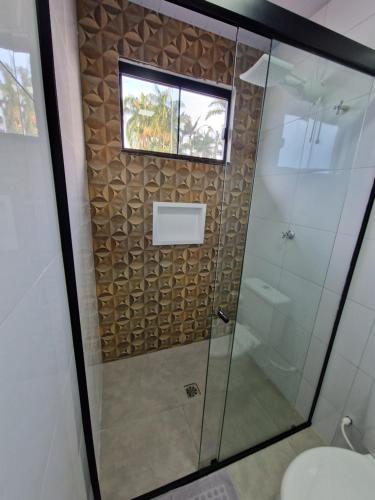 a shower with a glass door and a window at Condomínio Inn The Studio in Foz do Iguaçu