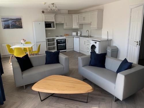 a living room with two couches and a table at Town Center Beautiful 1 Bed Apartment in Kinsale