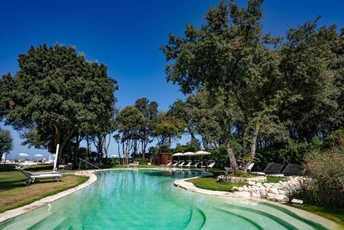 uma piscina num parque com árvores e cadeiras em Fortino Napoleonico em Ancona