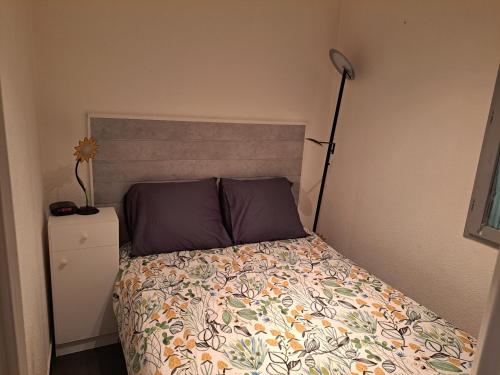 1 dormitorio con 1 cama con cabecero y lámpara en Appartement T2 à 300m de la mer, en Palavas-les-Flots