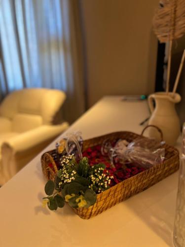 a basket of flowers on a table with a vase at Garden House Hotel in Río Cuarto