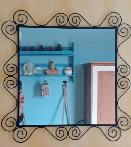 a mirror on a wall with a person taking a picture at Locanda D'Ogliastra, in Triei