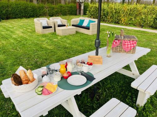 una mesa de picnic blanca con una bandeja de comida. en B&B Hoeve Fraai Achterhoek en Aalten