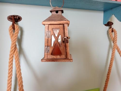 a lantern hanging on a wall with two ropes at Locanda D'Ogliastra, in Triei