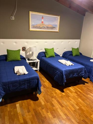 three beds in a room with a lighthouse on the wall at Garden House Hotel in Río Cuarto