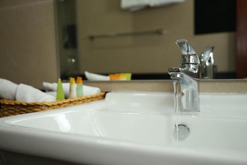 a bathroom sink with a faucet and a mirror at Spring Villas Kandy in Kandy