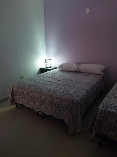 una camera con un letto e una lampada su un tavolo di PACHA PUNKU a San Carlos