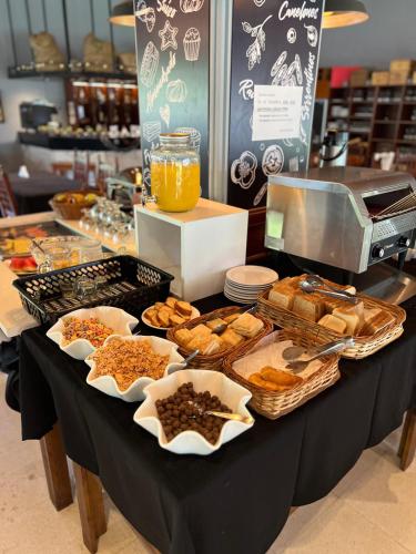 a table filled with different types of pastries and bread at Garden House Hotel in Río Cuarto