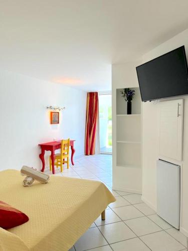 a living room with a table and a tv on the wall at Le Domaine Anse Marcel Beach Resort in Anse Marcel 
