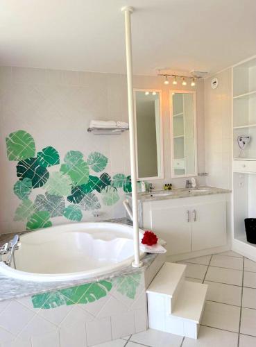 a bathroom with a large tub and a sink at Le Domaine Anse Marcel Beach Resort in Anse Marcel 