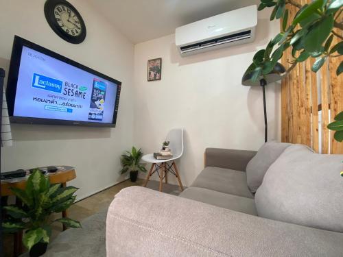 ein Wohnzimmer mit einem Sofa und einem Flachbild-TV in der Unterkunft The Sky view on Nimman 12 in Chiang Mai