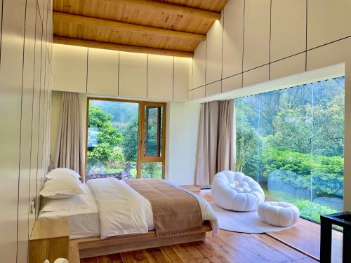 um quarto com uma cama e uma grande janela em Yangshuo Vivian Villa em Yangshuo