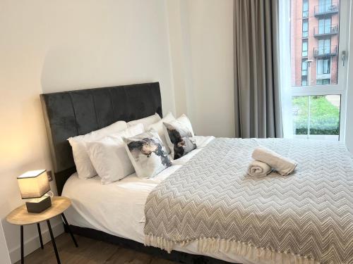 a bedroom with a bed with a large window at 2 bedroom Apartment in Manchester