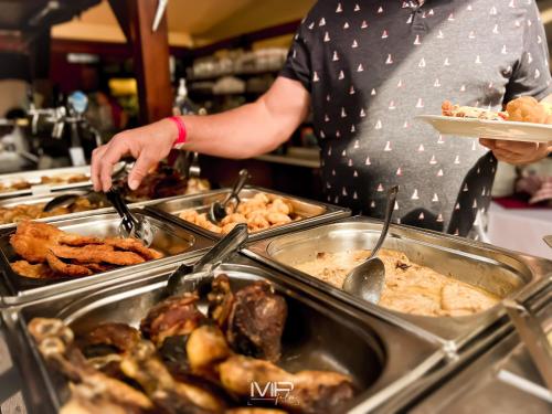 a man is preparing food in a buffet at Hotel Szent István in Eger