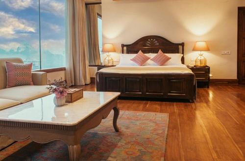 pokój hotelowy z łóżkiem i kanapą w obiekcie THE SHILLONG ADDRESS w mieście Shillong