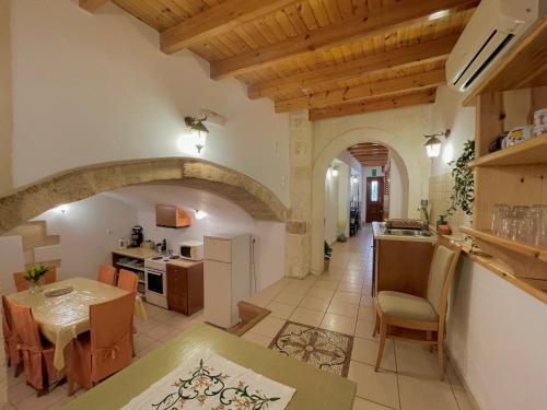 a large kitchen and dining room with an archway at Odyssey House in Chania