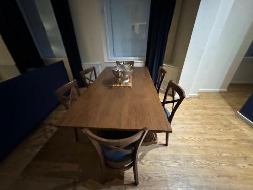 una mesa de madera con sillas y un tazón. en NolansBed en Dordrecht