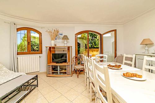 Il comprend une cuisine et un salon avec une table et une télévision. dans l'établissement Locations-06 L'Eugénie Gîte pour 8 au calme sur la Côte d'Azur, à Le Bar-sur-Loup