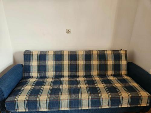 a plaid couch in a corner of a room at Apartmani Jović 2 in Mali Lošinj