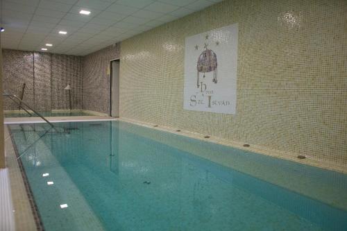 a large swimming pool with blue water in a room at Hotel Szent István in Eger