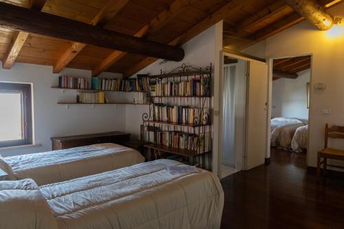 una camera con due letti e una libreria con libri di B&B Casanonni Borgo Angeli a Mantova