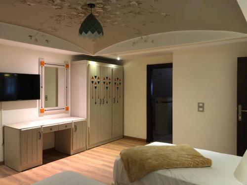 ein Schlafzimmer mit einem Bett und einem Schreibtisch. in der Unterkunft ALMADIAFAH APARTMENT - المضيفة للوحدات الفندقيه in Mansoura
