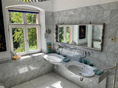 uma casa de banho com 2 lavatórios e 2 janelas em Art-be-and-b Appartement -Studios em Riegel