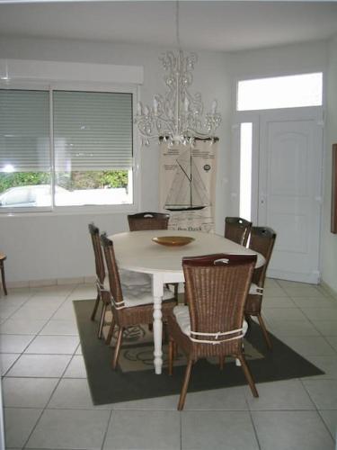 une salle à manger avec une table et des chaises blanches dans l'établissement Grande maison 40m de la plage de Pontaillac, à Royan