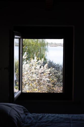 a window in a bedroom looking out at the water at B&B Casanonni Borgo Angeli in Mantova