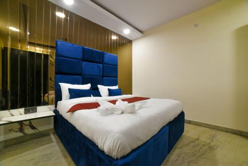 a bedroom with a large bed with a blue headboard at The Twenties Kamla Nagar in New Delhi
