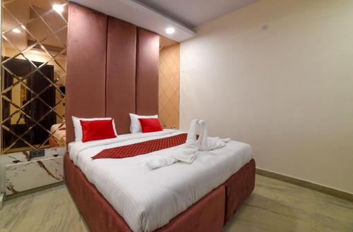a bedroom with a large bed with red pillows at The Twenties Kamla Nagar in New Delhi