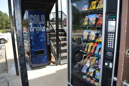 a soda vending machine on the side of a street at Sun Down Lodge in Locust Grove