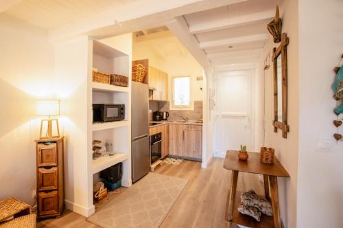 - une cuisine aux murs blancs et une table dans une chambre dans l'établissement SANVIVISA Cosy - Calme - Terrasse, à Grimaud