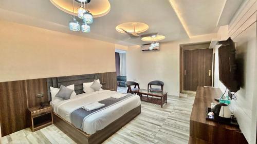 a bedroom with a bed and a flat screen tv at Raksha Suites & Banquet Greater Noida in Greater Noida