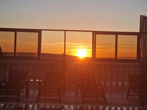 a person standing on a deck watching the sunset at Amazing Villa With Large Private Swimming Pool in Tangier