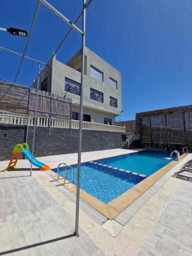 a swimming pool with a slide in front of a building at Amazing Villa With Large Private Swimming Pool in Tangier